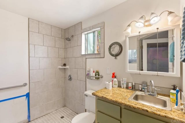 bathroom featuring tiled shower, vanity, and toilet