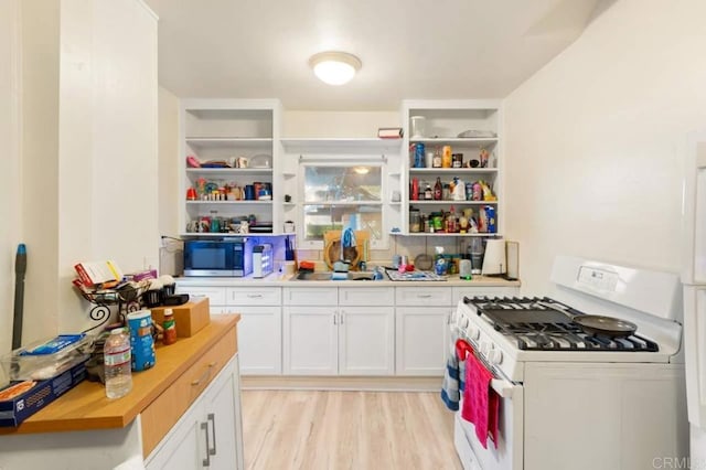 kitchen featuring light hardwood / wood-style floors, white cabinets, white gas stove, and wooden counters