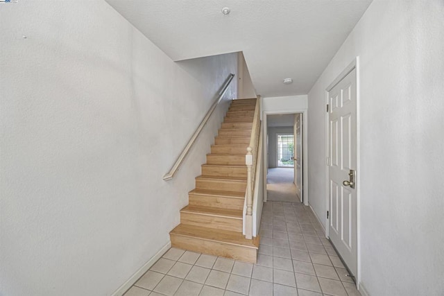 stairway featuring tile patterned flooring