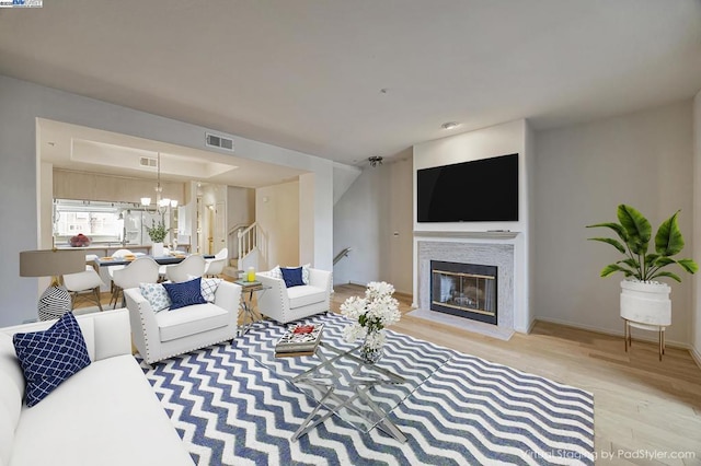 living room with light hardwood / wood-style flooring and a notable chandelier