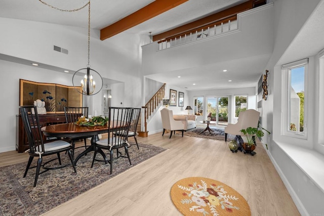 dining space featuring high vaulted ceiling, visible vents, stairway, and light wood finished floors