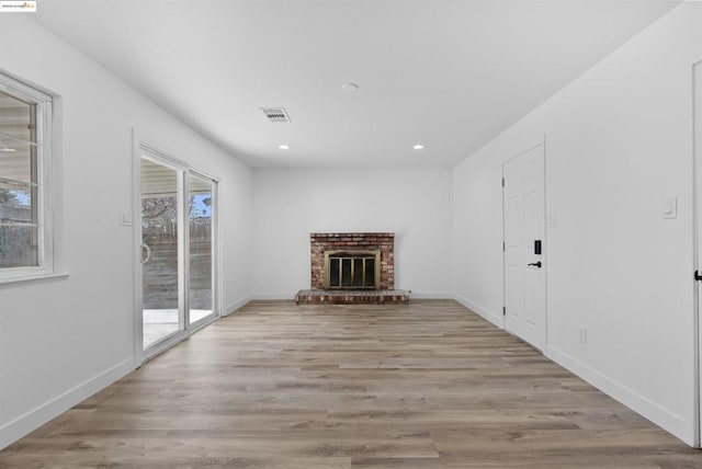 unfurnished living room with a fireplace and light wood-type flooring