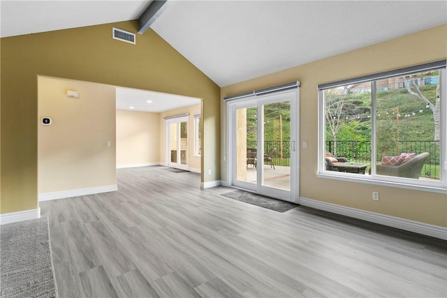 interior space with light hardwood / wood-style flooring and vaulted ceiling with beams