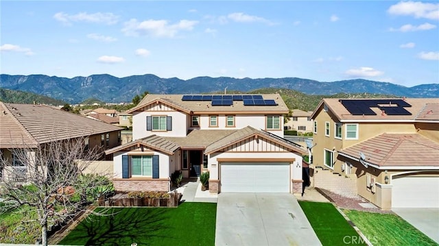 view of front of home with a mountain view, a front yard, and solar panels