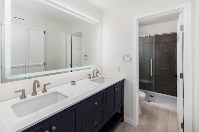 bathroom featuring vanity, toilet, and a shower with door