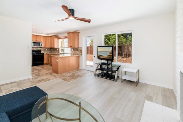 kitchen with black / electric stove, decorative backsplash, plenty of natural light, and kitchen peninsula