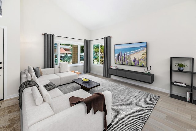 living room with light hardwood / wood-style flooring and high vaulted ceiling