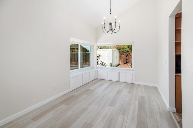 unfurnished dining area featuring a notable chandelier and light hardwood / wood-style floors