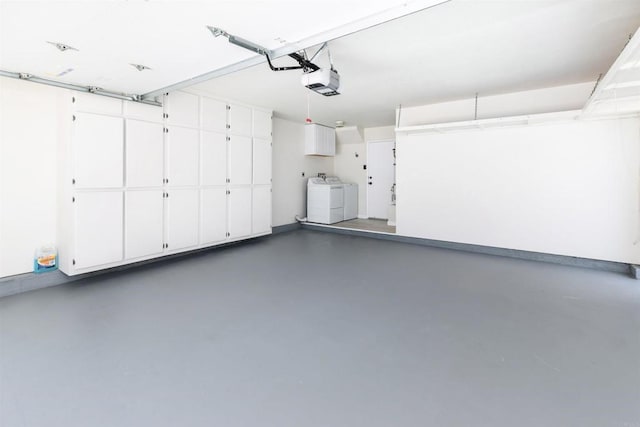 garage featuring a garage door opener and washer and dryer