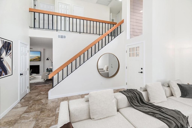 interior space with a towering ceiling and a fireplace