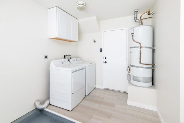 washroom featuring cabinets, washer and clothes dryer, light hardwood / wood-style floors, and strapped water heater