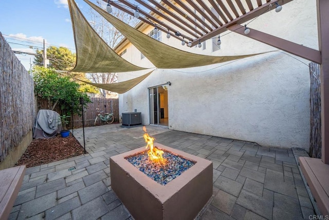 view of patio / terrace featuring central AC unit, a fire pit, and a pergola