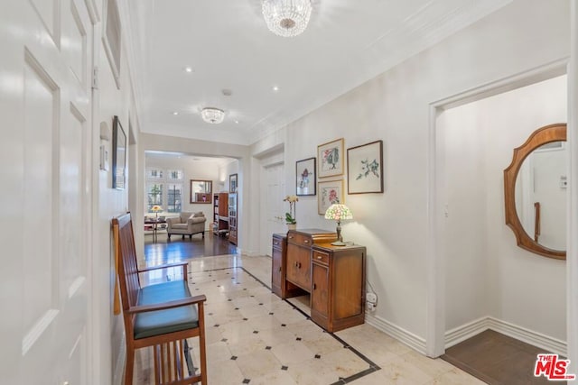 hall featuring crown molding and a notable chandelier