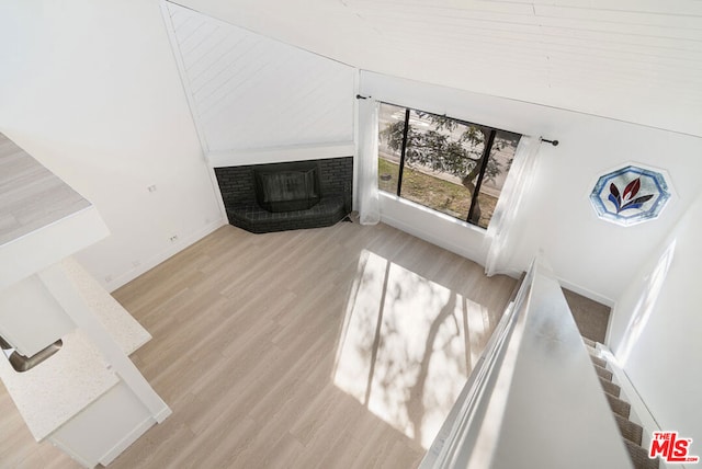 living room with light hardwood / wood-style floors and a brick fireplace