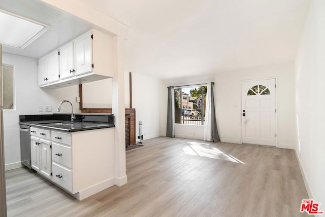 kitchen featuring sink, white cabinetry, and light hardwood / wood-style floors