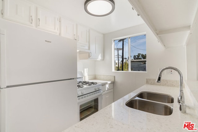 kitchen with sink, white appliances, white cabinetry, and light stone counters