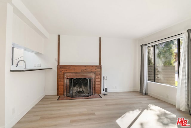 unfurnished living room with light hardwood / wood-style floors and a fireplace