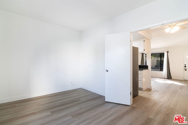 spare room with light wood-type flooring and ceiling fan