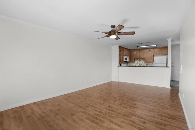 unfurnished living room with ceiling fan and wood-type flooring