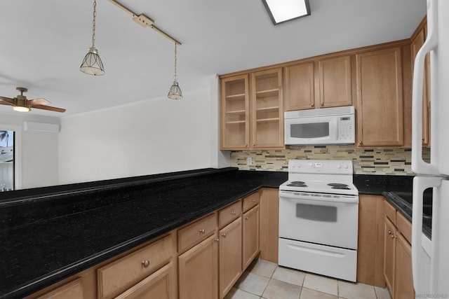 kitchen with hanging light fixtures, dark stone counters, light tile patterned floors, white appliances, and decorative backsplash