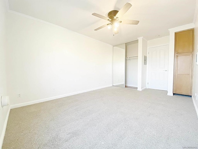 unfurnished bedroom featuring ceiling fan, light colored carpet, and crown molding