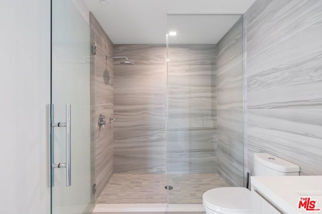 bathroom featuring vanity, toilet, and a shower with door