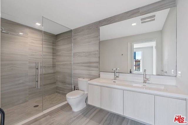 bathroom with vanity, toilet, and a shower with shower door