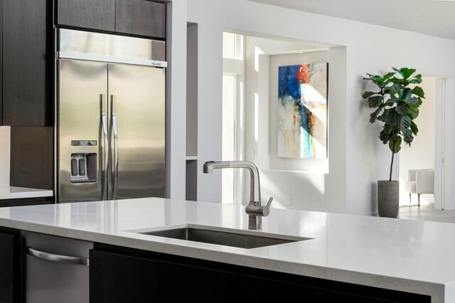 kitchen featuring built in fridge and sink