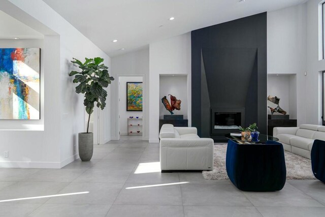 living room featuring vaulted ceiling and a large fireplace