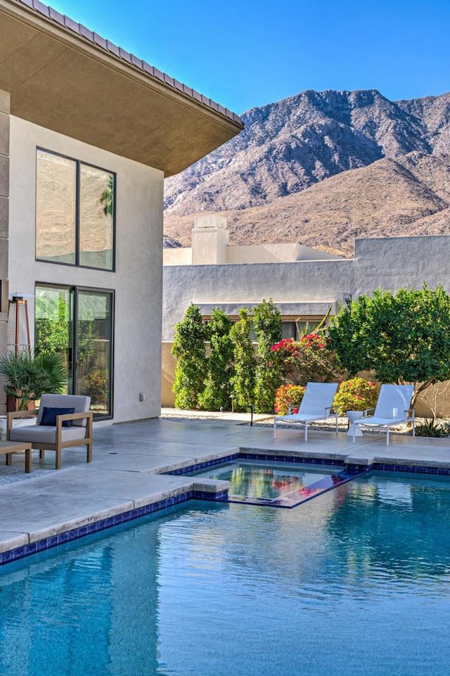 view of pool featuring a mountain view and a patio