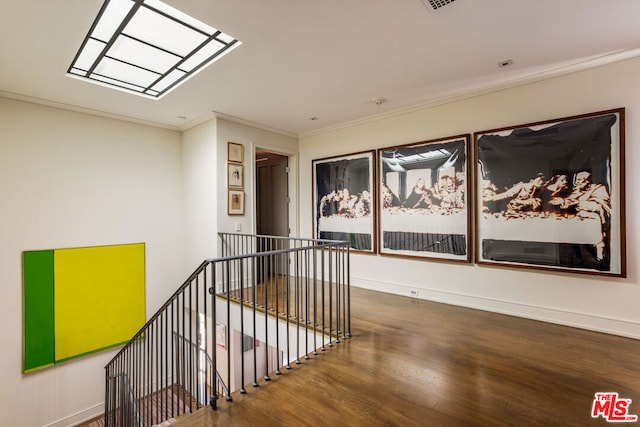 interior space featuring a skylight, ornamental molding, and wood-type flooring