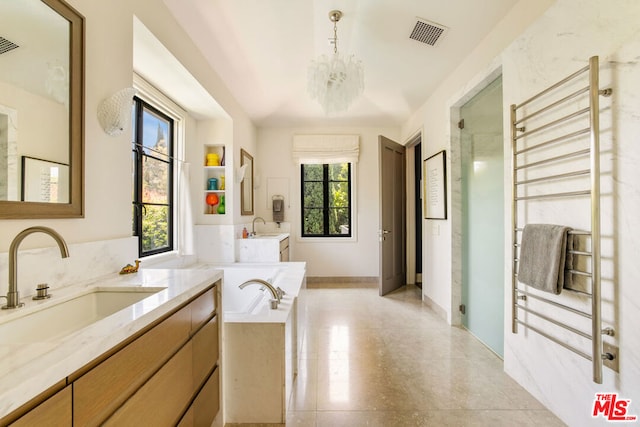 bathroom with plus walk in shower, a notable chandelier, and vanity