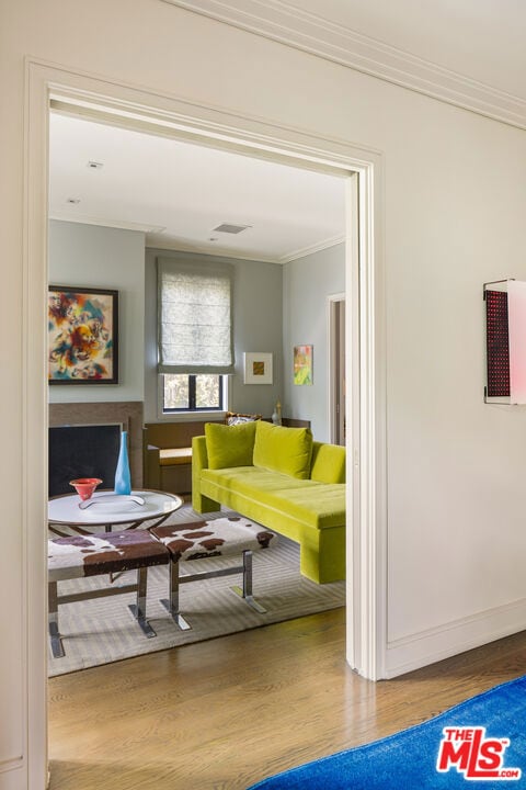 living room featuring crown molding and wood-type flooring