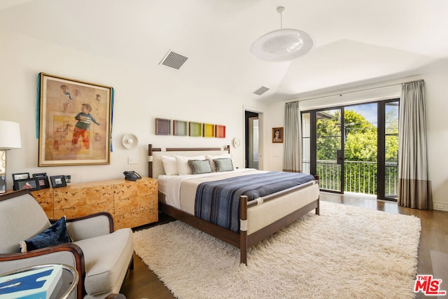 bedroom featuring access to outside, hardwood / wood-style floors, and lofted ceiling