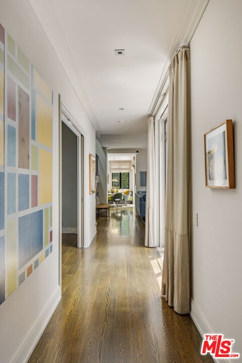 corridor featuring hardwood / wood-style flooring and crown molding