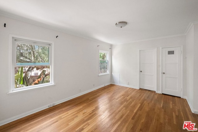 unfurnished room with crown molding and hardwood / wood-style flooring