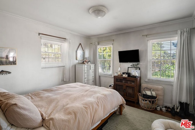 bedroom featuring crown molding, hardwood / wood-style floors, and multiple windows