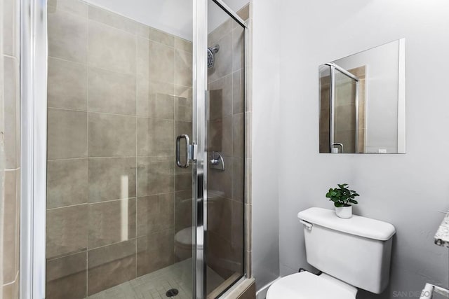 bathroom with toilet and a shower with shower door