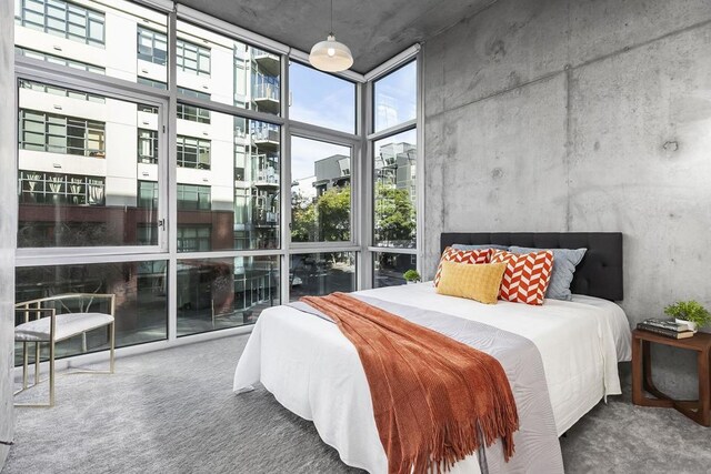 carpeted bedroom with floor to ceiling windows and a high ceiling