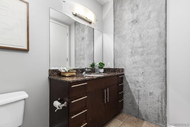 bathroom featuring toilet, tile patterned flooring, and vanity