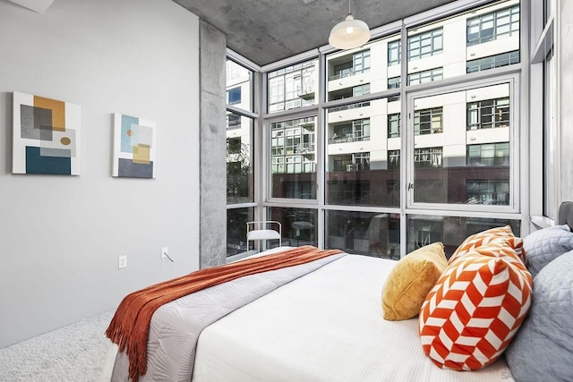 bedroom featuring a wall of windows and a high ceiling