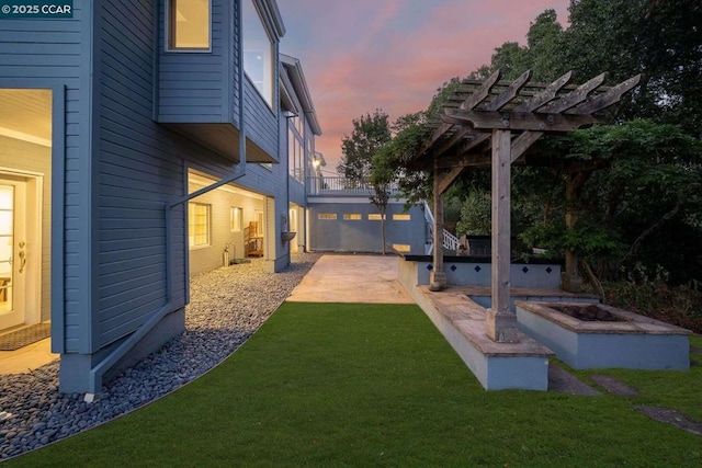 yard at dusk featuring a patio area and a pergola