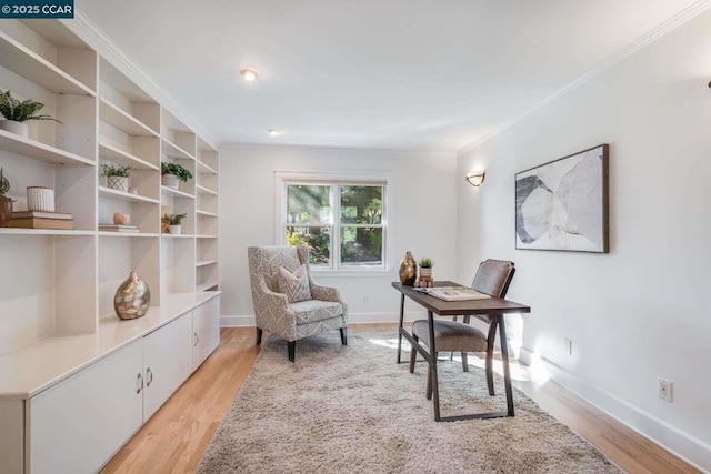 office area with light hardwood / wood-style floors and ornamental molding