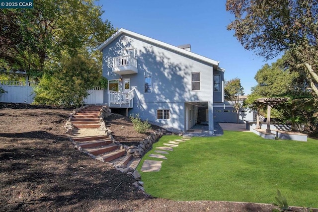 back of property with a balcony, a yard, and a pergola