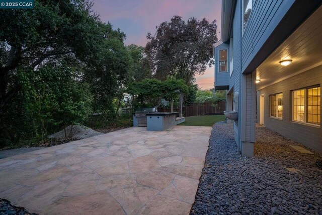 patio terrace at dusk featuring exterior kitchen