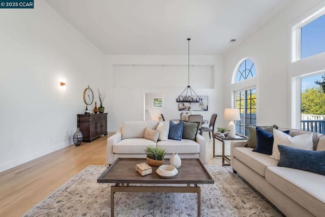 living room with crown molding and light hardwood / wood-style floors