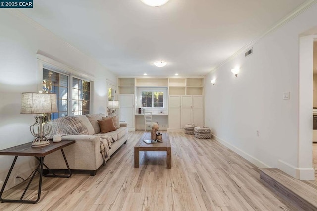 living room with built in features, light hardwood / wood-style flooring, and crown molding