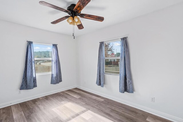 empty room with ceiling fan and light hardwood / wood-style flooring