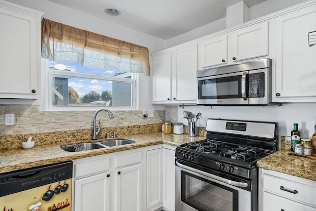 kitchen with white cabinets, light stone counters, appliances with stainless steel finishes, and sink