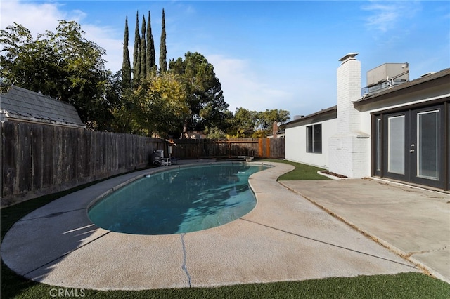 view of pool with french doors, a diving board, and a patio